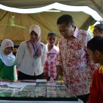 MANSOR Othman mendengar penjelasan beberapa kanak-kanak di gerai pameran bersempena Program Gerak Kerja Perdana Rakyat di Batu Maung.