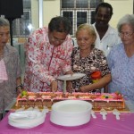 MANSOR Othman membantu beberapa warga emas memotong kek bersempena sambutan Hari Ibu Sedunia di Balai Raya Kampung Sungai Lembu.