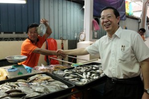 LIM Guan Eng (kanan) bersalaman dengan salah seorang penjual ikan di Astaka MPPP Batu Maung baru-baru ini.