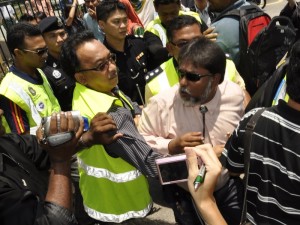 MOHAMED Ghani dikerumuni anggota polis di luar bangunan Dewan Undangan Negeri di sini.