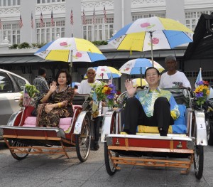 KETUA Menteri bersama isteri, melambai ketika bersiap-sedia untuk dibawa mengelilingi bandar George Town dengan beca. 