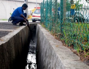 S. Darmalingam memancut air bagi mengeluarkan kotoran pada dinding longkang di Pasar Bagan Ajam di sini. 