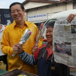 TAN Kim Hoon (kanan sekali) menunjukkan keratan akhbar tahun lalu sambil diperhatikan oleh Lim Guan Eng di Taman Reservoir, Air Itam di sini baru-baru ini. 