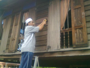 MOHD. Kamil Abu Bakar menggantikan jendela yang telah usang.