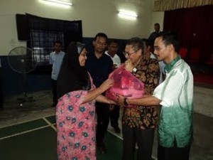 MANSOR Othman (dua dari kanan) bersama Salehin Mohamed (kanan sekali) menyampaikan sumbangan kepada salah seorang penduduk kurang berkemampuan di Majlis Hi-Tea Bersama TKM I di Dewan Sri Kenangan, Taman Emas, Bagan Ajam, di sini, baru-baru ini.