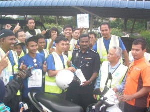 WAKIL belia program Pandu Cermat Jiwa Selamat ‘Jom Perangi Jenayah’ bersalaman dan menyerahkan dengan seorang pegawai polis di Seberang Perai.