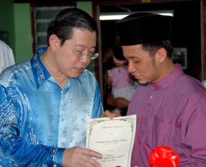 KETUA Menteri Pulau Pinang, Y.A.B. Lim Guan Eng (kiri) menyerahkan sijil penghargaan kepada Muhammad Asyraf Mohd. Ridzuan pada majlis Rumah Terbuka DUN Sri Delima di sini baru-baru ini. 