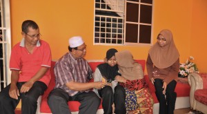 TARIAH Abd. Jalil (dua dari kanan) mengucup anaknya sambil diperhatikan Mohd. Salleh Man di kediamannya di Taman Ara Indah di sini baru-baru ini. 