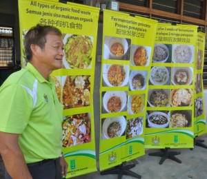 SALAH seorang kakitangan MPSP di samping sepanduk Program Kitar Semula dan Membuat Kompos Sisa Dapur Organik di Permatang Nibong di sini baru-baru ini.