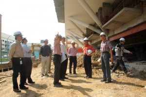 KETUA Menteri (tengah, berbaju putih) diberi penerangan oleh pegawai bertugas mengenai perkembangan projek  Pembinaan Pusat PKS di Bayan Lepas di sini baru-baru ini. 