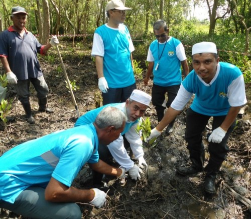 MOHD. Kamil Abu Bakar (kanan sekali) bersama Mansor Othman (bertopi) dan Maktar Shapee (duduk, dua dari kanan) menanam pokok bakau bersempena penganjuran PBI di Kampung Sungai Chanaam di sini baru-baru ini.