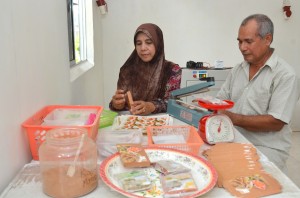 MD. Saad Salleh (kanan) dan Siti Aminah Ariffin sedang membungkus pek-pek rempah basah keluaran mereka