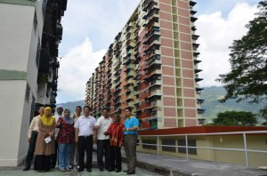 WONG Hon Wai (empat dari kanan) bersama sebahagian penduduk menunjukkan tanda b a g u s s amb i l berlatarbelakangkan Flat Kampung Melayu yang telah siap dicat semula.