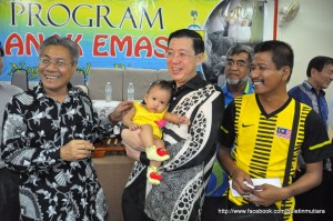 TIMBALAN Ketua Menteri I, Datuk Mansor Othman (kiri sekali) mencuit anak emas yang didukung Ketua Menteri pada majlis penyampaian di Penanti di sini