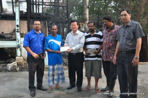 CHOW Kon Yeow (tiga dari kiri) menyampaikan sumbangan bantuan bencana kepada keluarga mangsa di sini baru-baru ini.