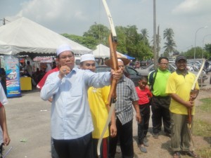 TIMBALAN Pengerusi Majlis Agama Islam Pulau Pinang, Datuk Mohd. Salleh Man (kiri sekali) menunjukkan bakat memanah sempena penganjuran Karnival Harmoni Peringkat Daerah SPU di sini baru-baru ini.  