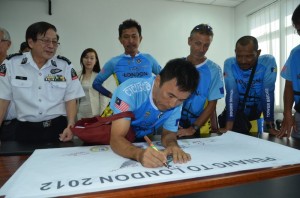 Teh Yee Cheu menandatangani sepanduk program kayuhan amal pada majlis sidang akhbar di sini baru-baru ini.