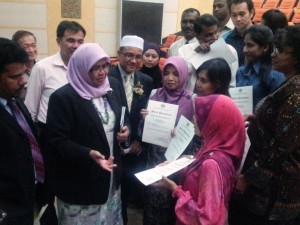 MAIMUNAH Mohd. Sharif saling berinteraksi dengan fasilitator Flextronics (pegang sijil) sambil diperhatikan oleh Muruthy Murigiah (kiri sekali) dan Rozali Mohamud (berkopiah) selepas selesai Majlis Penyampaian Anugerah Komuniti Mampan 2012/2013 di sini baru-baru ini.