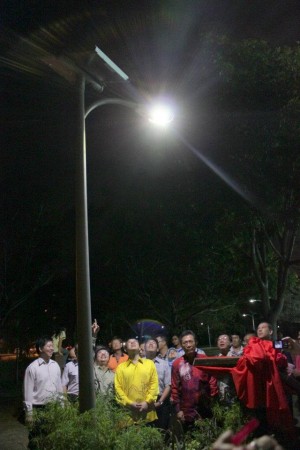 KETUA Menteri (tengah, berbaju kuning) meninjau salah satu lampu solar LED yang telah disiap dipasang pada Majlis Pelancaran Pemasangan Tiang Lampur Solar LED di padang Sunway Tunas di sini baru-baru ini.