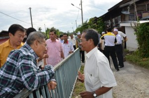 MANSOR Othman (kiri sekali) ditemani Lim Hock Seng (dua dari kiri) mengadakan perbincangan dengan salah seorang penduduk bersempena lawatan ke Kampung Berembang di sini baru-baru ini.