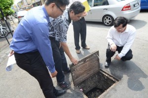 CHOW Kon Yeow (kanan sekali) meninjau saluran air dalam longkang di persimpangan Lebuh Cintra dan Lebuh Kimberly. 
