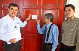 SOON Lip Chee (kiri sekali) bersama Ahli Majlis MPSP, Ahmad Farid (tengah) menunjukkan salah satu contoh pelekat yang dilekatkan di pintu hadapan sebuah rumah di Seberang Perai.