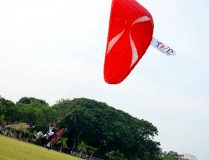 JURUTERBANG paramotor melakukan pendaratan sambil mengibarkan bendera TPO Forum 2012 yang bakal berlangsung di Pulau Pinang pada 17 hingga 20 September 2012 ini.