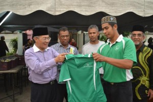 MANSOR Othman (kiri sekali) menyampaikan kemeja-t kepada salah seorang wakil Pemuda Qaryah Masjid Kubang Semang sambil diperhatikan Abdul Malik Abul Kassim (kanan sekali) pada Majlis Penyampaian Inisiatif Meraikan Guru-guru SAR Peringkat Daerah SPU dan SPT di sini baru-baru ini.