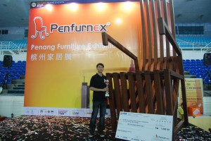 LEE Kuan Hong bergambar bersama-sama kerusi gergasi ciptaannya sempena penganjuran PENFURNEX 2012 di sini baru-baru ini.