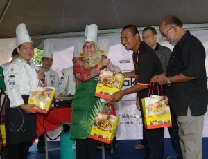 AR. Patahiyah Ismail (tengah) menyampaikan hadiah kepada salah seorang pemenang Pertandingan Memasak Di Dalam Taman 2012 di sini baru-baru ini.