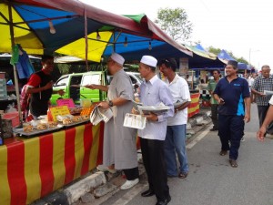 BOB Lokman (berkopiah, dua dari kiri) bersama Muhasdey Muhamad (depan sekali) mengedarkan risalah Kerajaan Negeri dan naskah Buletin Mutiara kepada para peniaga pasar malam Bertam Perdana, Pinang Tunggal di sini baru-baru ini.