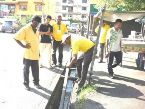 R.S.N. RAYER (bertopi) turun padang menyertai JKKK Taman Tun Sardon bergotong-royong bagi membersihkan sistem saliran yang tersumbat di sini.