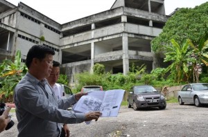 CHOW Kon Yow menunjukkan pelan asal bangunan empat tingkat yang terbengkalai lebih 12 tahun dan bakal dibangunkan semula di sini baru-baru ini