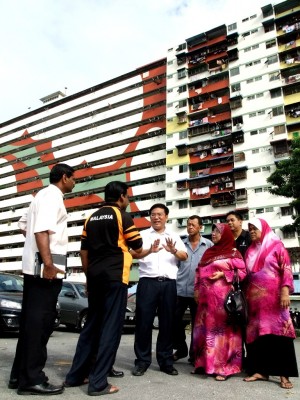 PARA penduduk dan Wong Hon Wai mengadakan perbincangan berlatarbelakangkan Rumah Pangsa Kampung Melayu yang telah siap dicat.