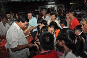 MOHD. Salleh Man (depan, kiri sekali) menyampaikan ‘ang pow’ kepada kanak-kanak sempena Sempena Sambutan Tahun Baru Cina Kampung Cross Street 2 di sini baru-baru ini.