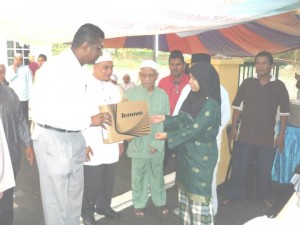 SITI Nur Adilah Abdul Wahab (dua dari kanan) menerima sumbangan komputer riba daripada  S.N. Rayer (kiri sekali) sempena Majlis Berbuka Puasa di Dewan JKKK Sungai Gelugor di sini baru-baru ini.   