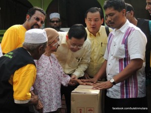 SALAH seorang penerima sumbangan berkongsi pengalaman dengan Ketua Menteri sambil diperhatikan Jagdeep Singh Deo (belakang kiri, berbaju kuning) dan Koid Teng Guan (hadapan, dua dari kanan) pada majlis penyampaian sumbangan di Kampung Kebun Lama di sini baru-baru ini.