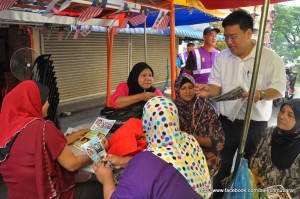 WONG Hon Wai (berdiri, kanan sekali) mengedarkan risalah kepada para penduduk Flat Kampung Melayu di sini baru-baru ini.