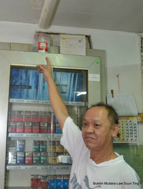 A shopkeeper pointing to the leak from the roof.