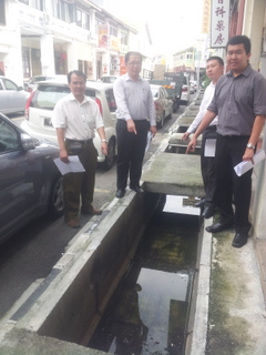 NG Wei Aik (dua dari kiri) bersama-sama Bee Heng Huat (paling kiri) dan dua Pegawai Khasnya menunjukkan kawasan parit tanpa penutup di Jalan Sungai Ujong di sini barubaru ini.