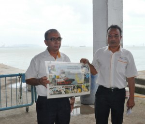 FISNOL Ainon Mahmud (kanan) menunjukkan artikel menjelaskan antara latihan yang dijalankan oleh krew feri ketika kecemasan sempena lawatan Ketua Menteri ke Terminal Feri PRTU di sini baru-baru ini.