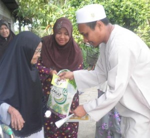 ROSIDI Hussain (kanan) menyampaikan sumbangan kepada salah seorang penerima di Kampung Pasir Gebu di sini baru-baru ini