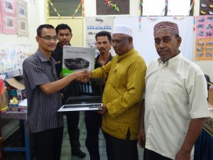 SALEHIN Mohamed (kiri sekali) menyampaikan sumbangan komputer riba kepada Mohamad Nor Bakar (dua dari kanan) sambil diperhatikan ahli qaryah Surau Bagan Tambang di sini baru-baru ini.