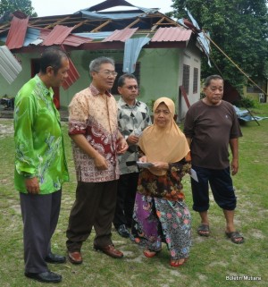 AZIZAH Yunus (dua dari kanan) menerima cek daripada Mansor Othman (dua dari kiri) sambil ditemani Jusni Ismail (kiri sekali) dan Alias Saad (tiga dari kiri) bersempena lawatan khas ke lokasi kejadian di sini baru-baru ini.