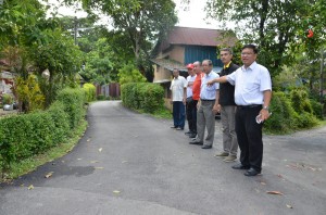 亚依淡区州议员黄汉伟（右1）巡视已竣工的安乐村道路铺路工程。