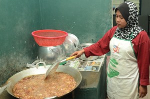 SALAH seorang kakitangan sedang menggoreng bawang yang telah siap dipotong. 