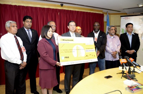 ஜோய்ஸ் லீ சுவான் மாதிரி காசோலையை ஜெக்சன் தியகோ அவரிடம் வழங்கினார்.(உடன் மாநில் அரசியல் தலைவர்கள் மற்றும் காற்பந்து உயர் அதிகாரிகள்)