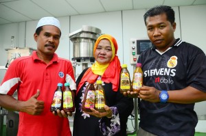 KAK Izz sambil diapit oleh Abdul Latiff Abdul Rahim (kiri) dan anaknya menunjukkan produk-produk yang dihasilkan.  