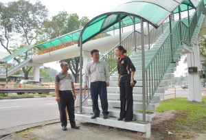 槟州首长政治秘书黄汉伟（中）巡视亚依淡商务小学旁重新粉刷后的行人天桥。