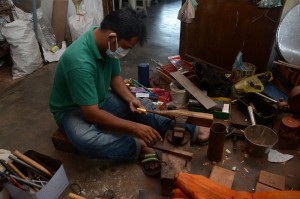 DOLAH sedang menyiapkan salah satu peralatan kraftangan yang ditempah. 